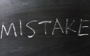 The word mistake is written on a blackboard in chalk