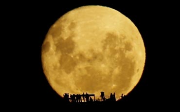 Silhouttes gather to watch the moon rise